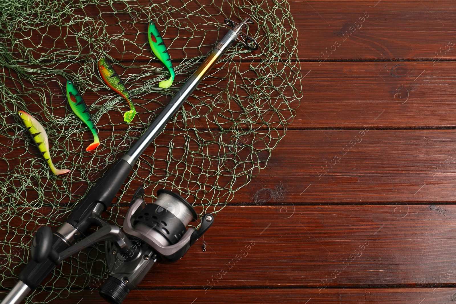 Photo of Fishing spinning, net and lures on wooden background, flat lay. Space for text