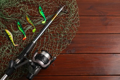 Photo of Fishing spinning, net and lures on wooden background, flat lay. Space for text