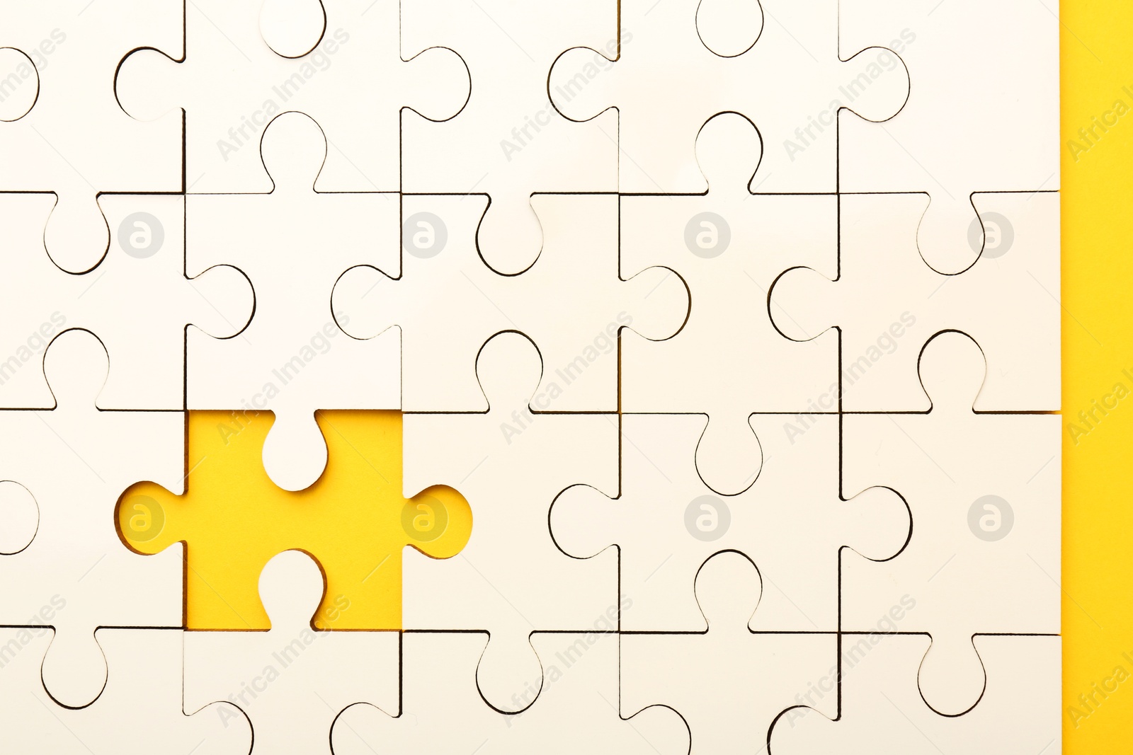 Photo of White puzzle with missing piece on yellow background, top view