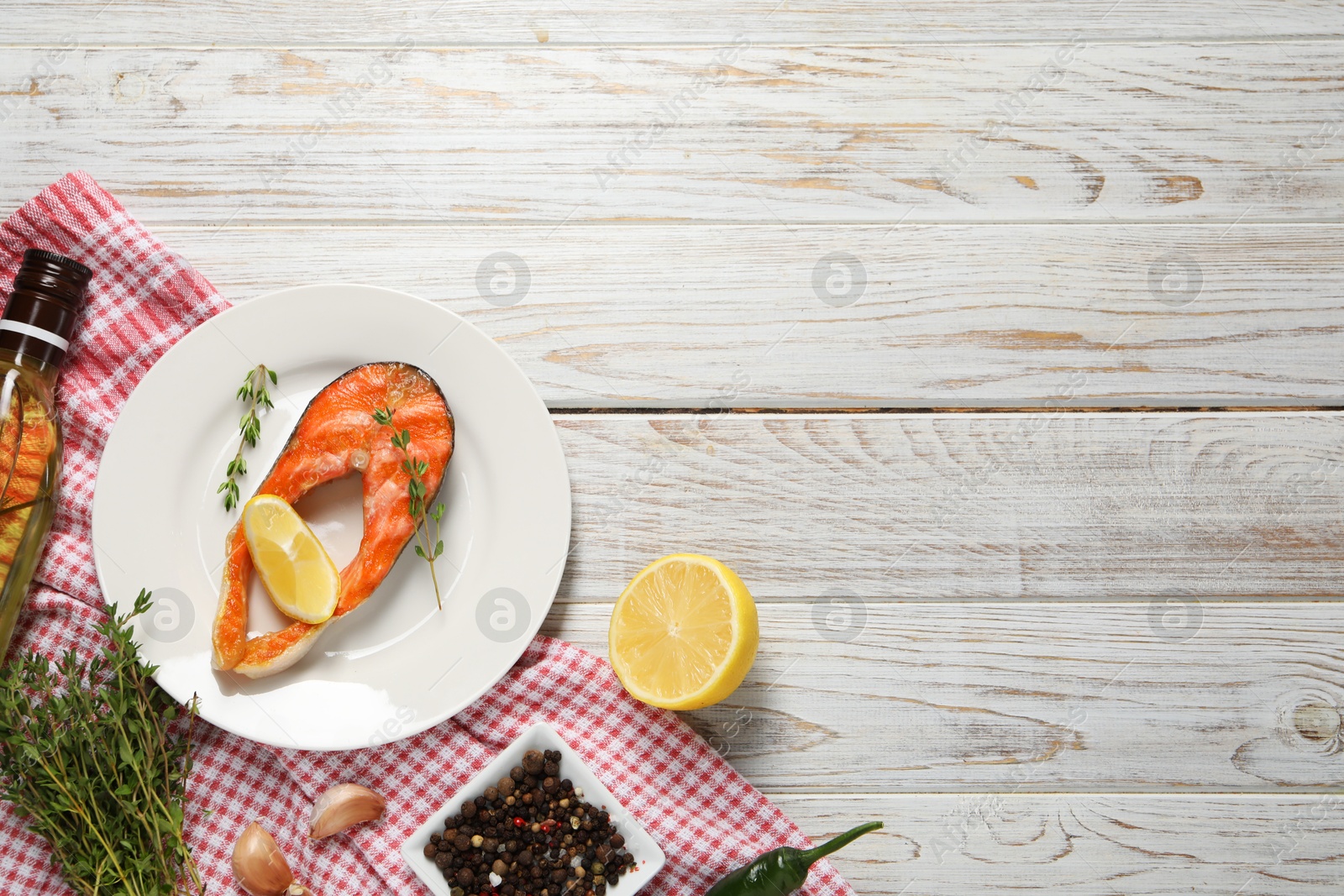 Photo of Tasty grilled salmon steak, lemon and spices on wooden table, flat lay. Space for text