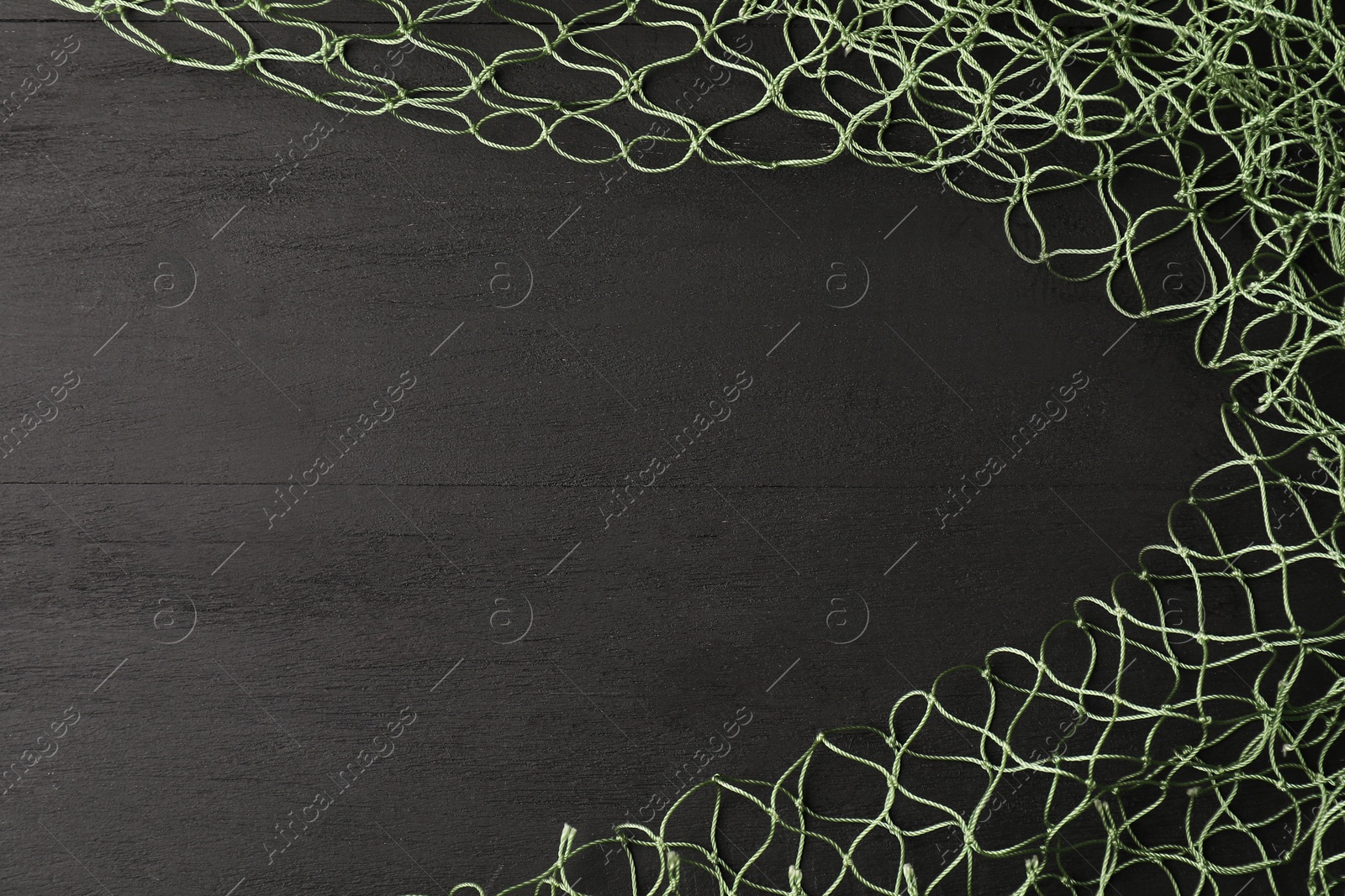 Photo of Green fishing net on grey wooden table, top view. Space for text