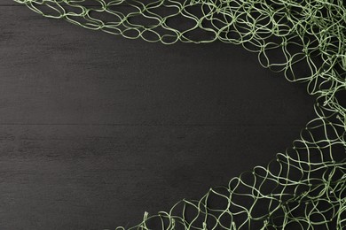 Green fishing net on grey wooden table, top view. Space for text