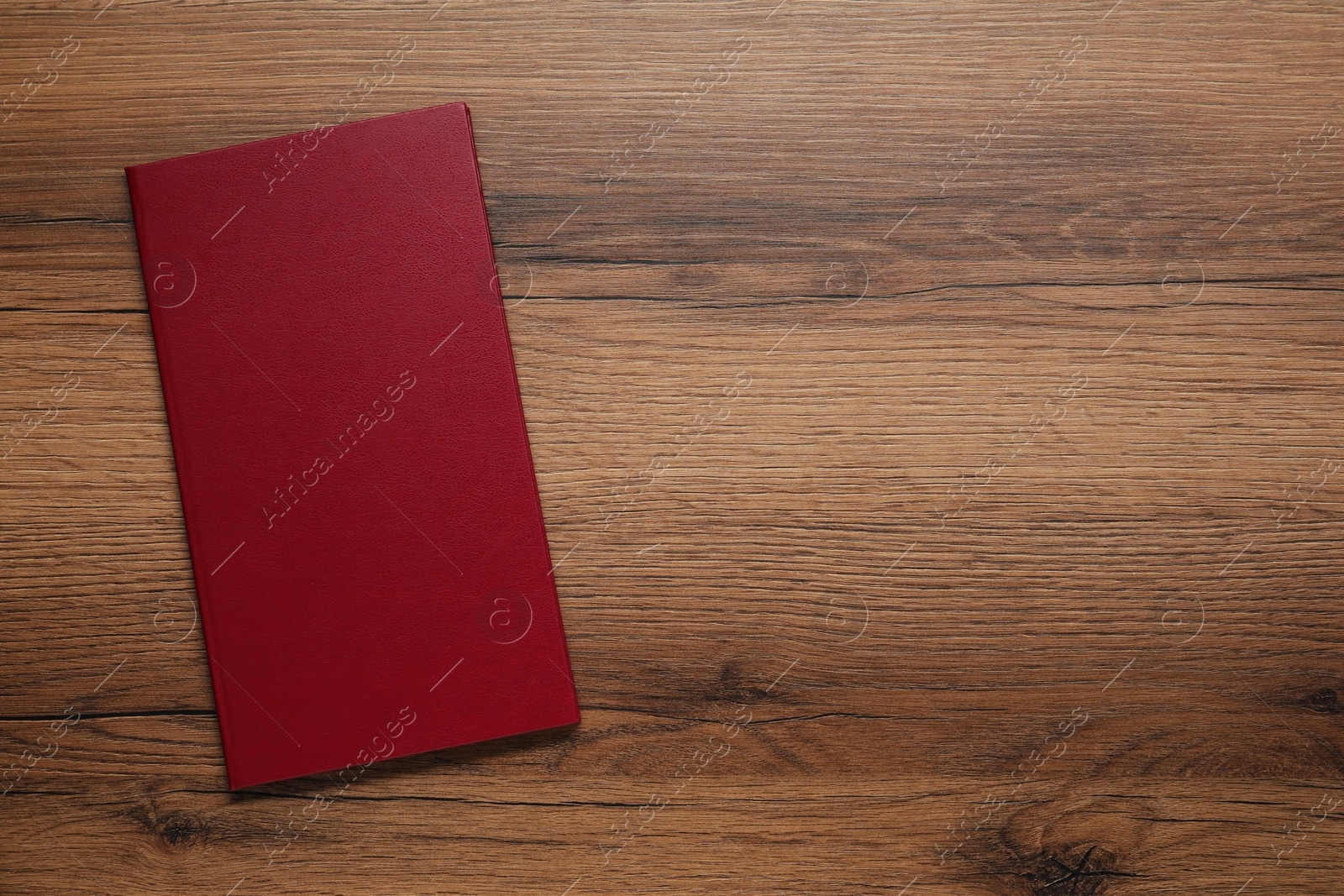 Photo of Hardcover book on wooden table, top view. Space for text