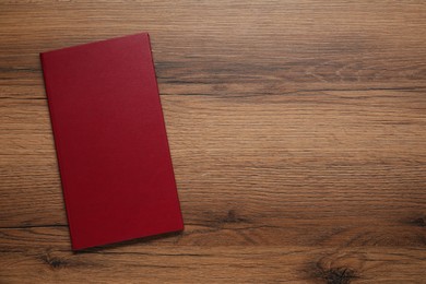 Photo of Hardcover book on wooden table, top view. Space for text