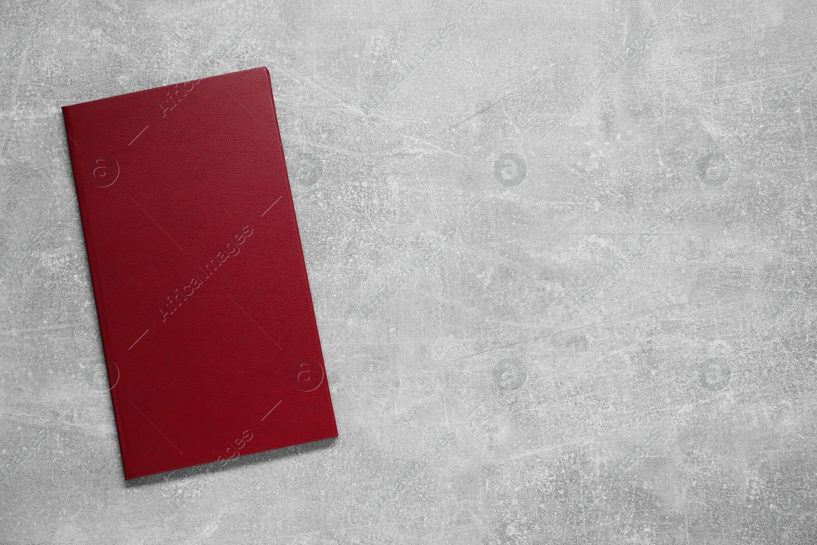 Photo of Hardcover book on grey textured table, top view. Space for text