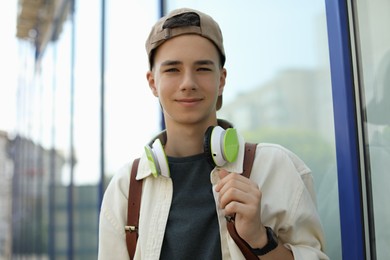 Photo of Portrait of teenage boy with headphones outdoors