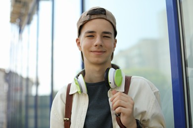 Photo of Portrait of teenage boy with headphones outdoors