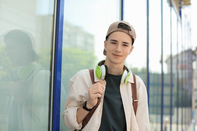 Photo of Portrait of teenage boy with headphones outdoors