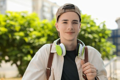 Photo of Portrait of teenage boy with headphones outdoors