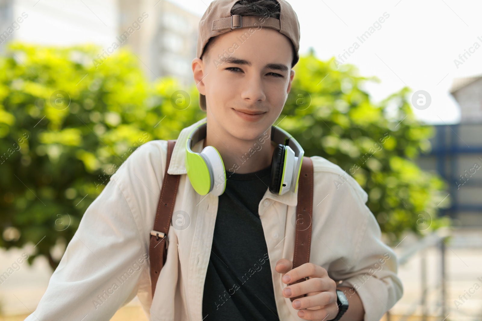 Photo of Portrait of teenage boy with headphones outdoors