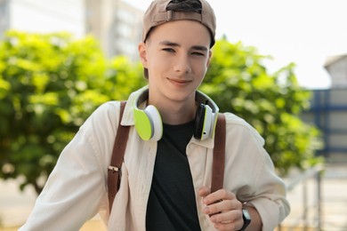 Portrait of teenage boy with headphones outdoors