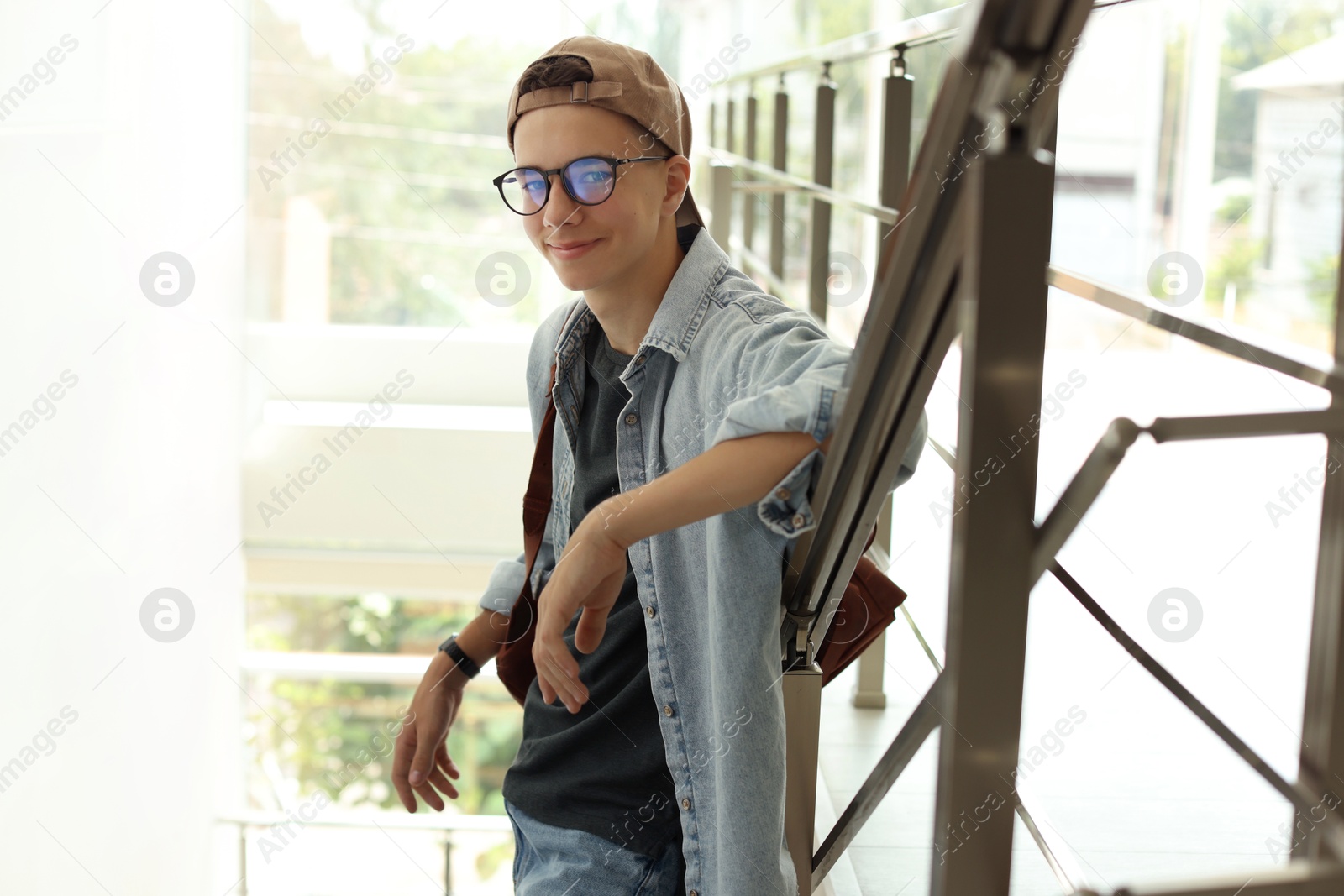 Photo of Portrait of teenage boy near railings indoors