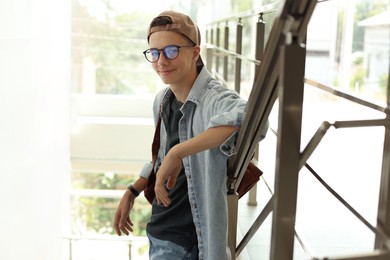 Portrait of teenage boy near railings indoors