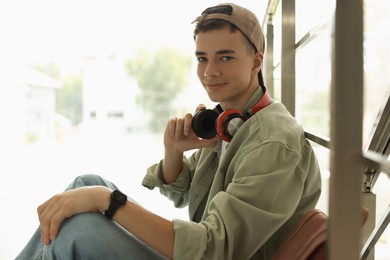 Photo of Portrait of teenage boy near railings on blurred background