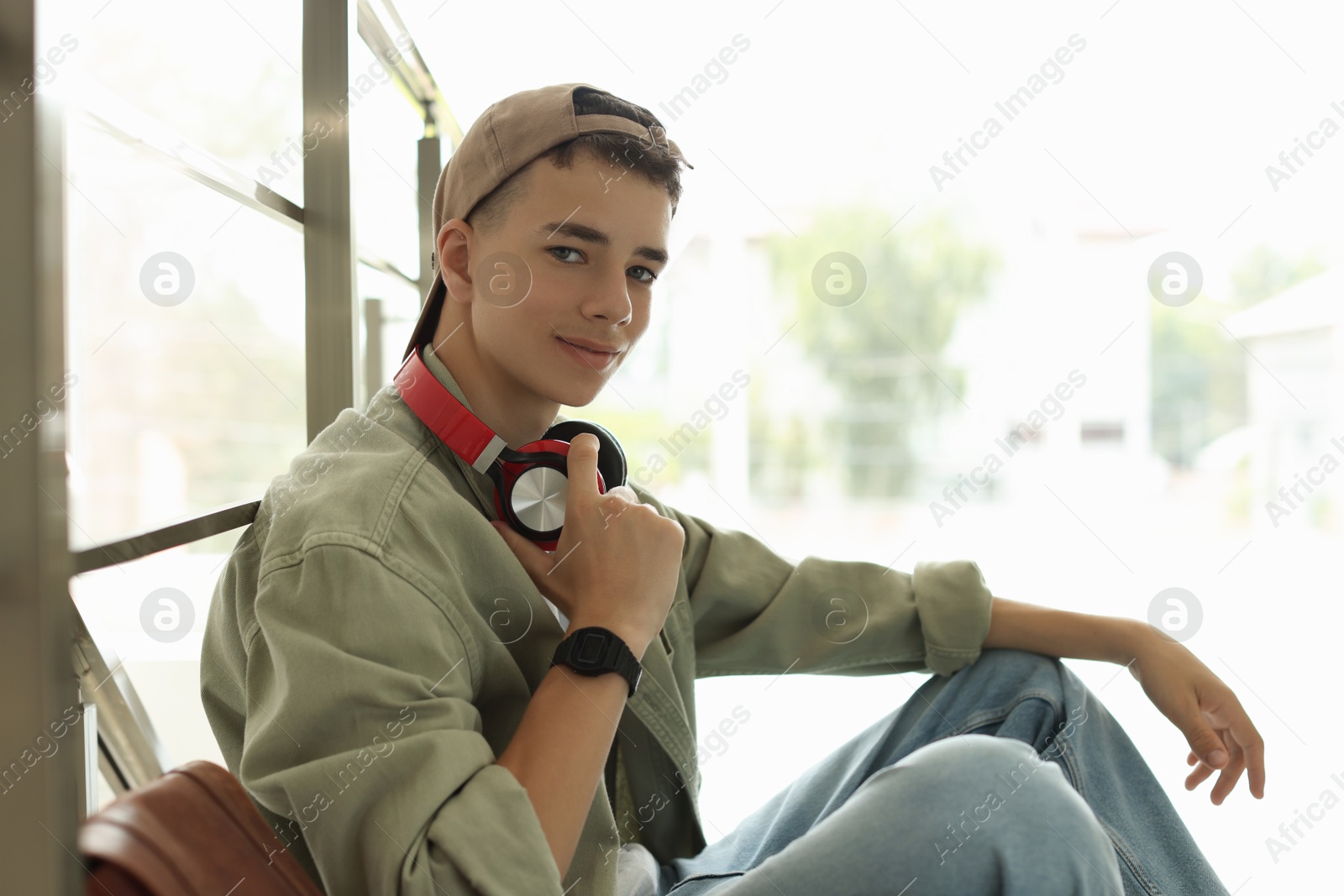 Photo of Portrait of teenage boy near railings on blurred background