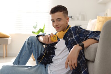 Photo of Portrait of teenage boy with headphones at home