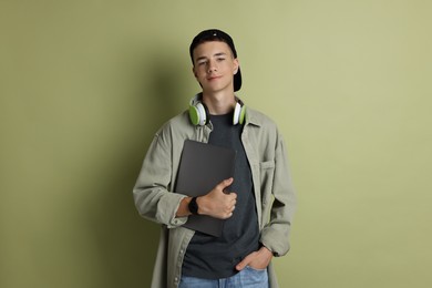 Photo of Portrait of teenage boy with laptop on green background