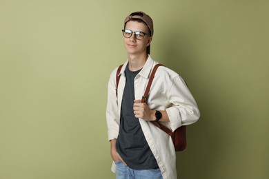 Photo of Portrait of teenage boy with backpack on green background