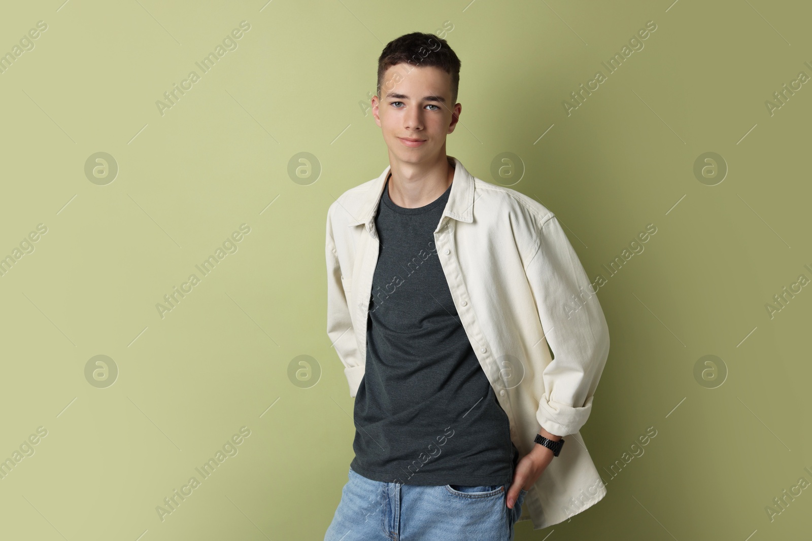 Photo of Portrait of teenage boy on green background. Space for text