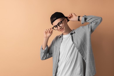 Photo of Portrait of teenage boy on dark beige background. Space for text