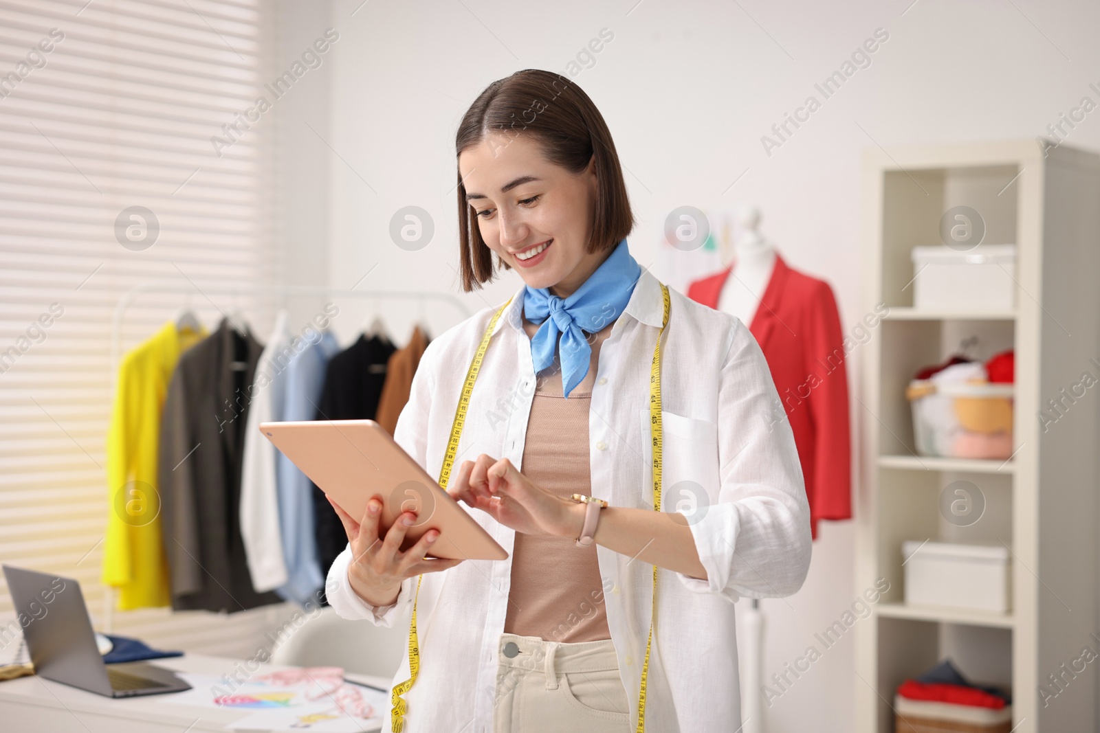 Photo of Fashion designer with tablet working in workshop