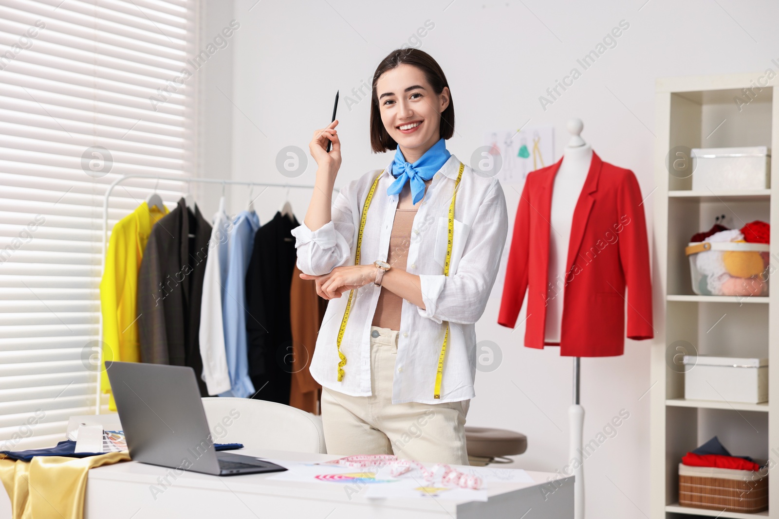 Photo of Fashion designer with pencil near table in workshop