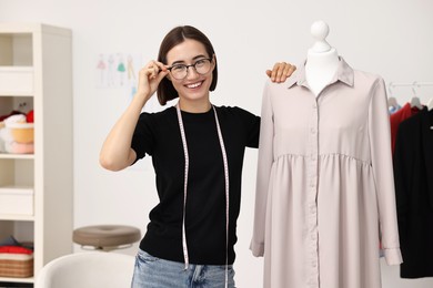 Photo of Fashion designer with beige dress in workshop