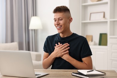 Young man using sign language during video call indoors