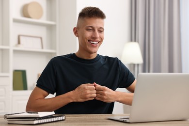 Young man using sign language during video call indoors