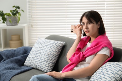 Photo of Beautiful woman with smartphone listening to voice message at home