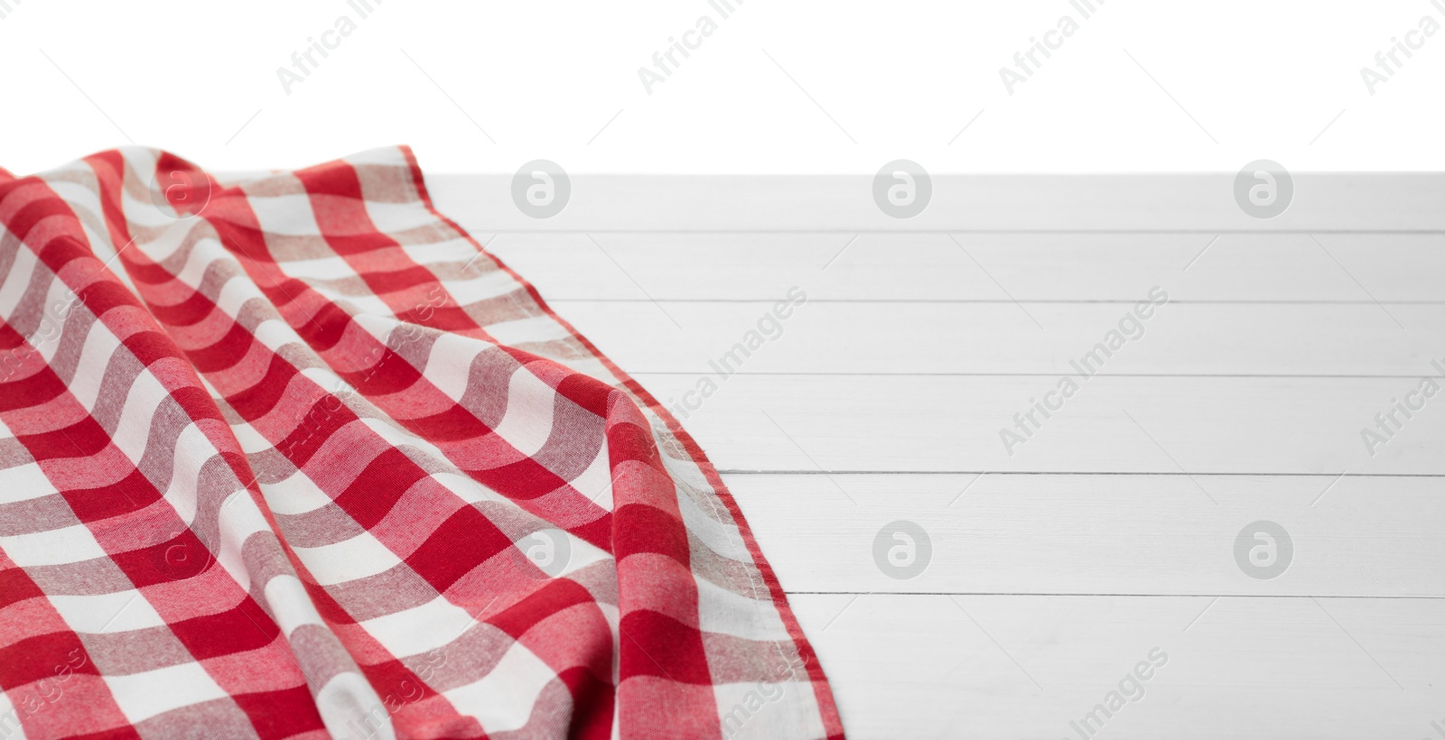 Photo of Crumpled tablecloth with checkered pattern on wooden table against white background