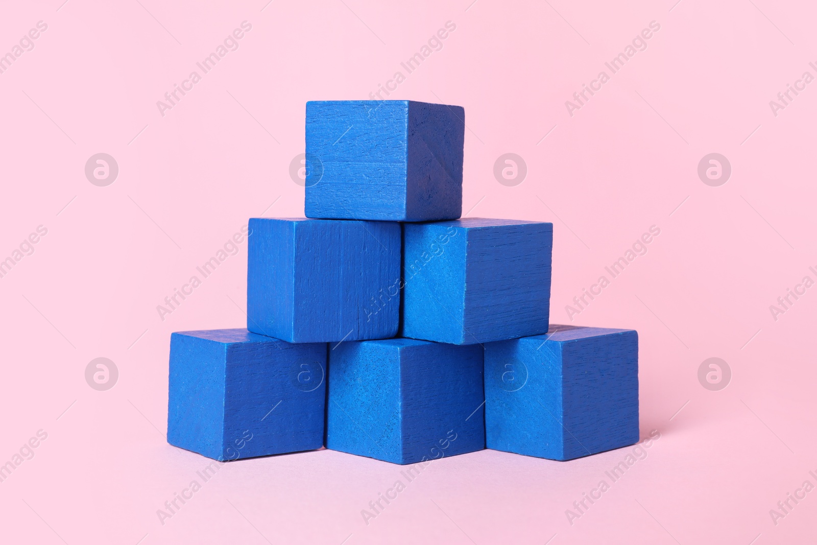 Photo of Many blank blue cubes on pink background