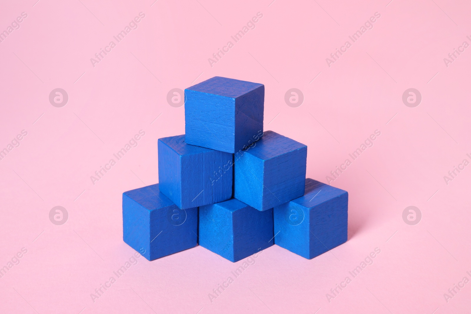 Photo of Many blank blue cubes on pink background