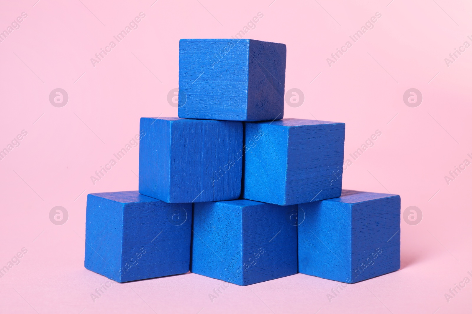 Photo of Many blank blue cubes on pink background, closeup