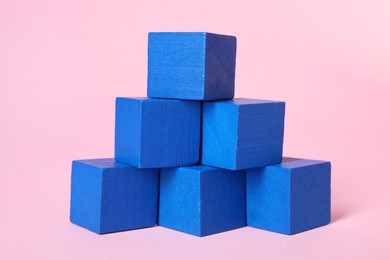 Photo of Many blank blue cubes on pink background, closeup