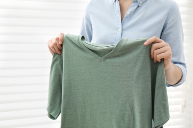 Photo of Woman with green shirt at home, closeup