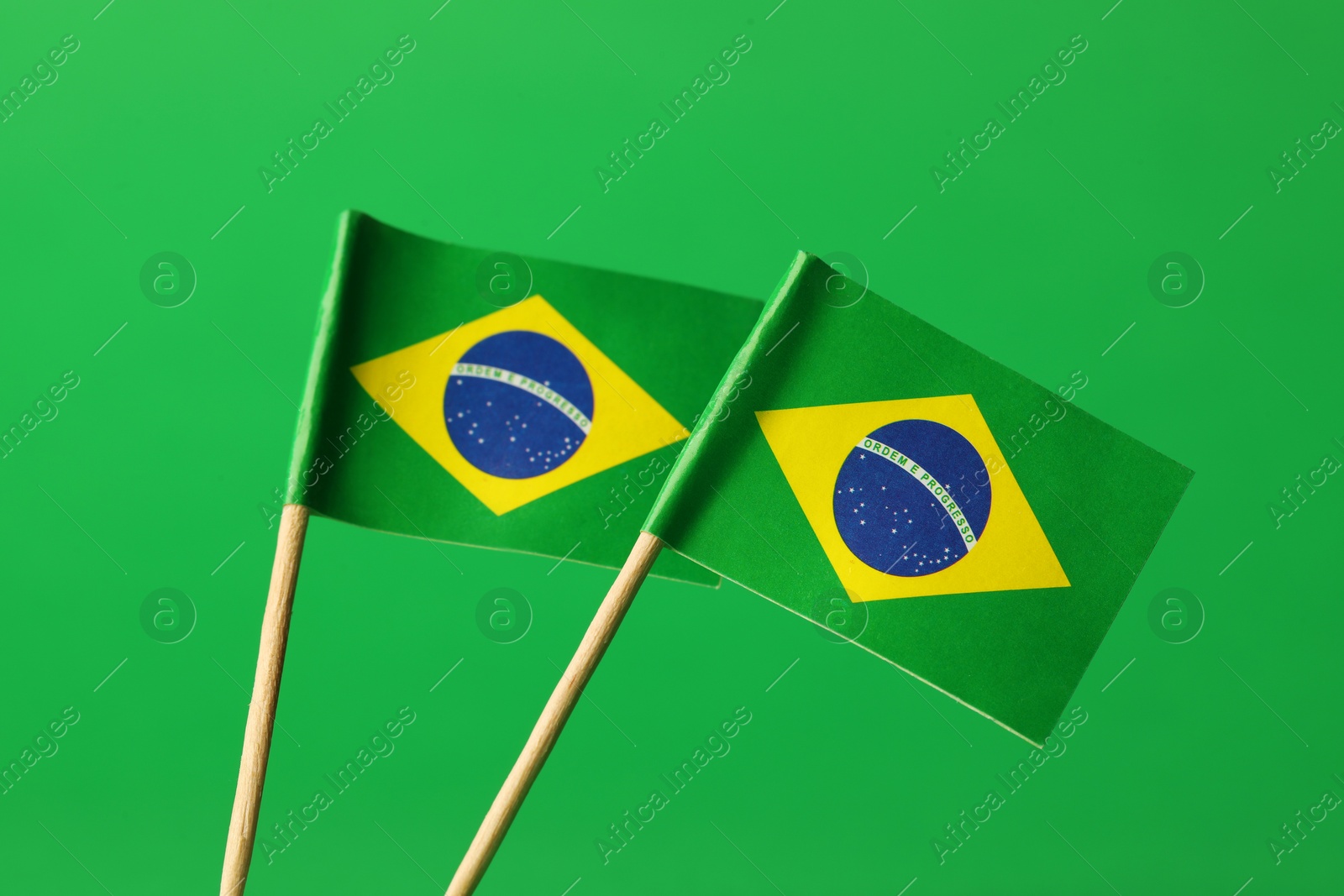 Photo of Small paper flags of Brazil on green background