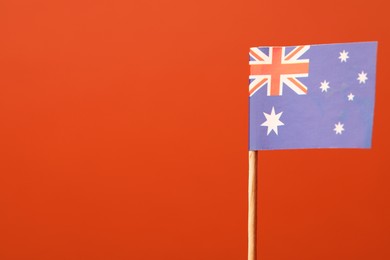 Small paper flag of Australia on orange background, space for text