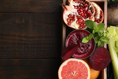 Photo of Glass of tasty beetroot smoothie, fresh vegetables, fruits and mint in box on wooden table, top view with space for text. Vegan drink