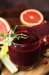 Photo of Tasty beetroot smoothie with microgreens in glass on table, closeup. Vegan drink