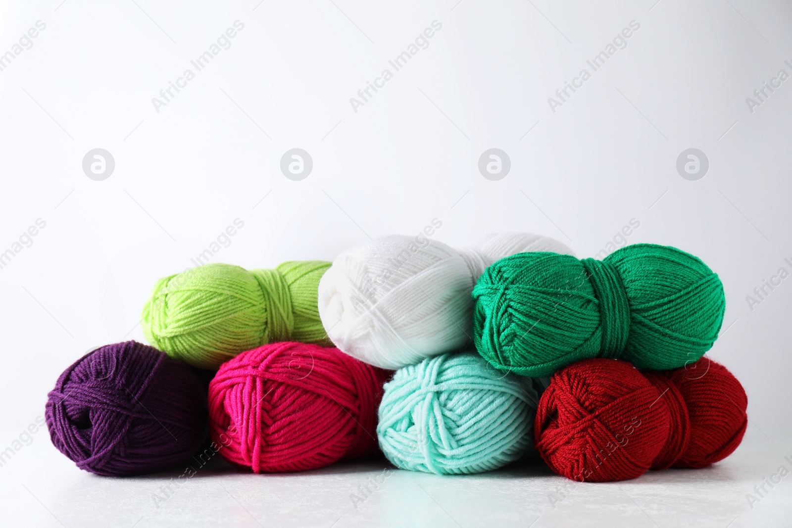 Photo of Many soft skeins of yarn on light grey background