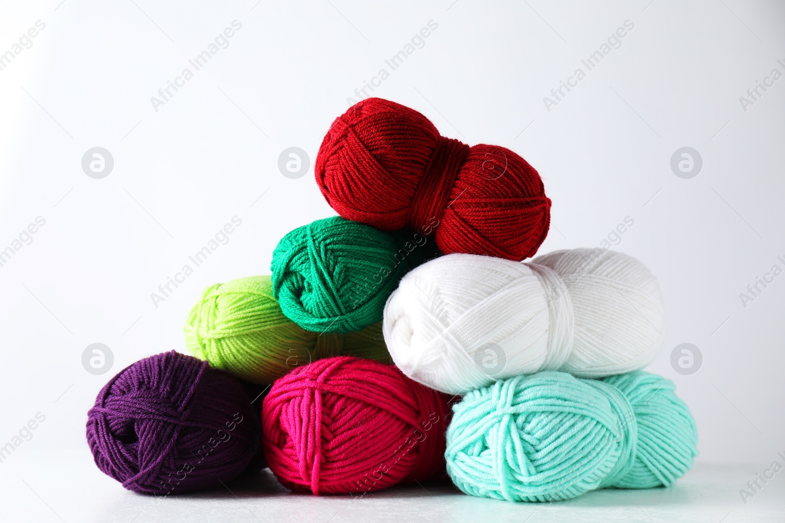 Photo of Many soft skeins of yarn on light grey background