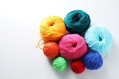 Photo of Many soft skeins of yarn on light grey background, flat lay. Space for text