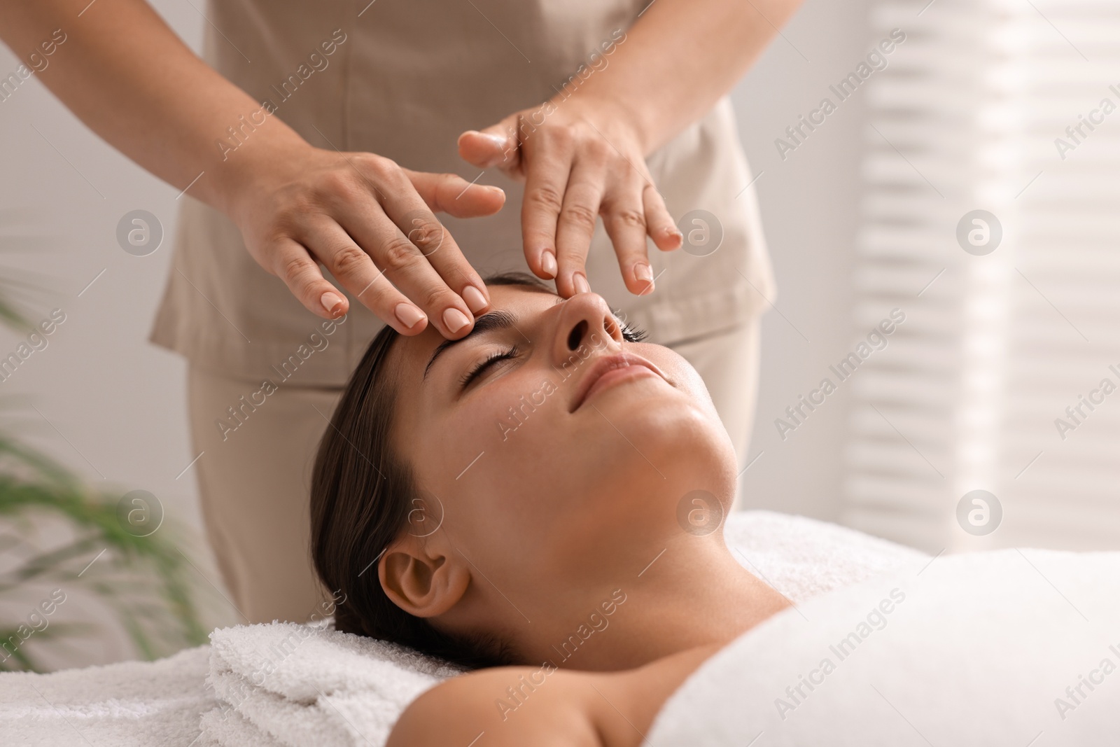 Photo of Attractive woman enjoying face massage, closeup. Beauty procedure