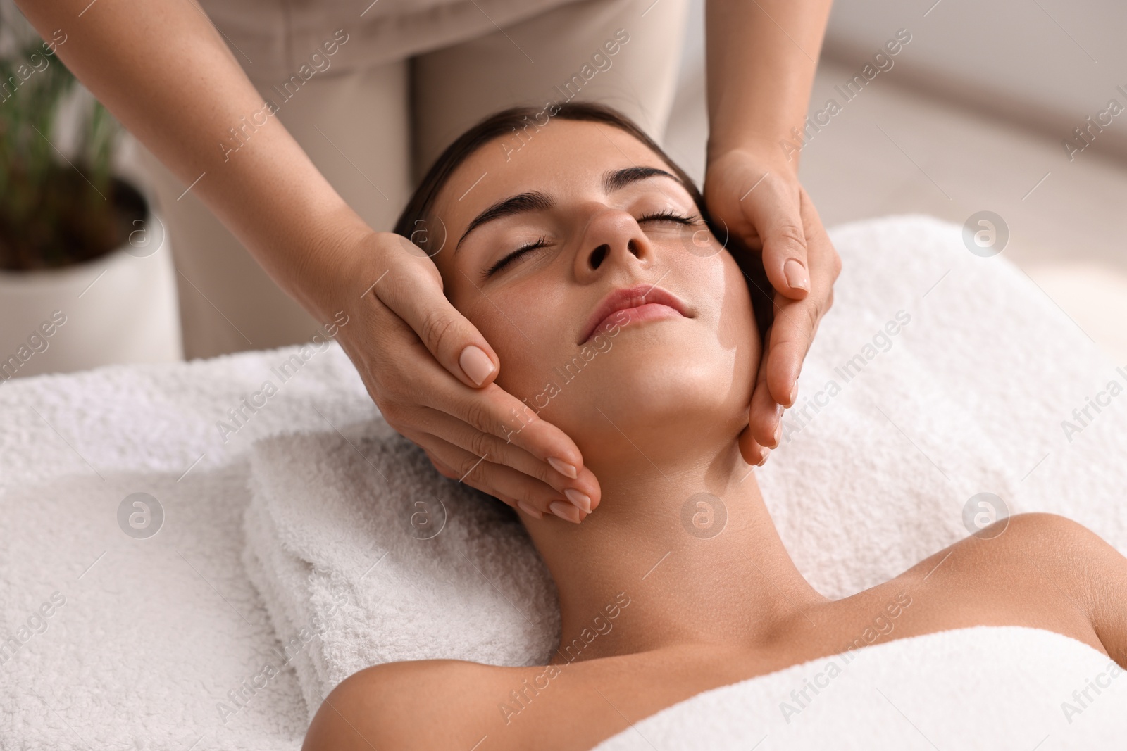 Photo of Attractive woman enjoying face massage, closeup. Beauty procedure