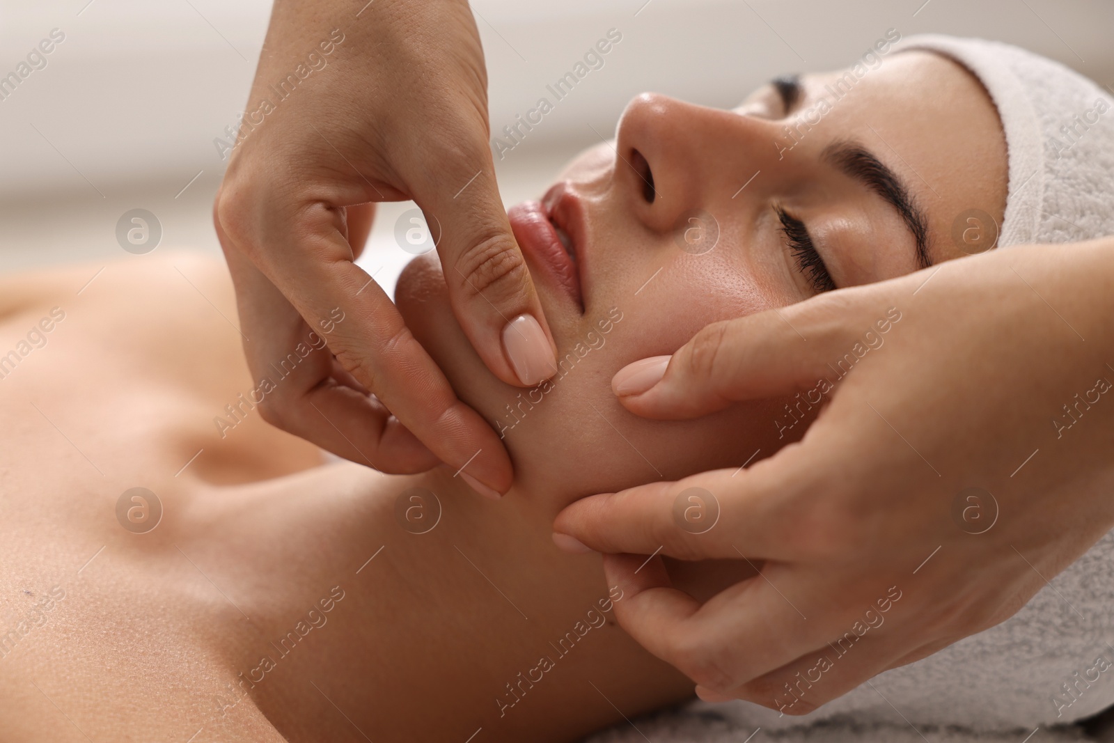 Photo of Attractive woman enjoying face massage, closeup. Beauty procedure