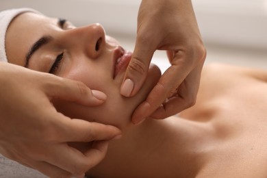 Photo of Attractive woman enjoying face massage, closeup. Beauty procedure