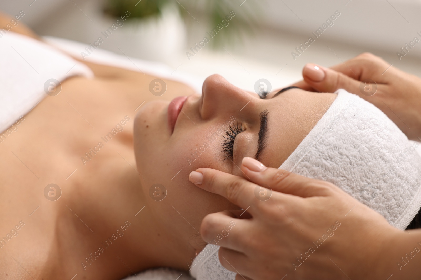 Photo of Attractive woman enjoying face massage, closeup. Beauty procedure