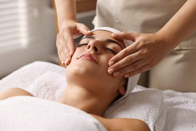 Attractive woman enjoying face massage, closeup. Beauty procedure