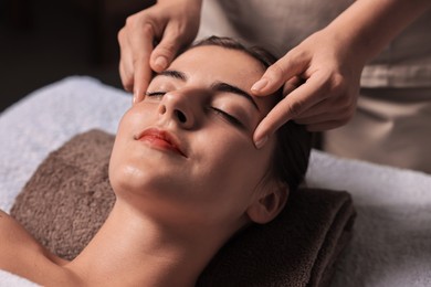 Photo of Attractive woman enjoying face massage, closeup. Beauty procedure